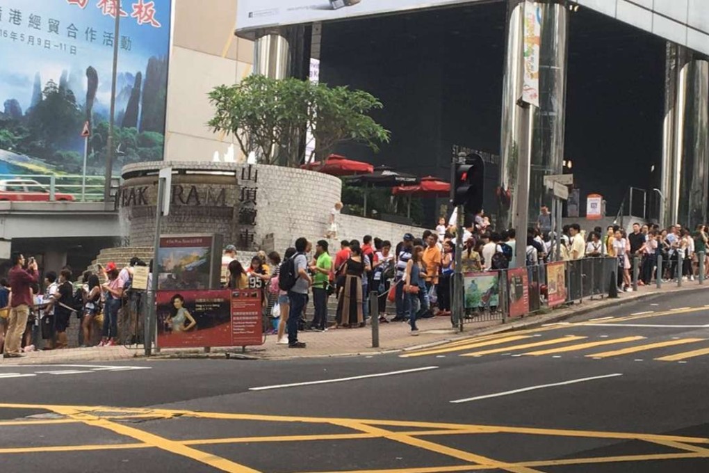 Tourists line up for replacement buses at the Garden Road Peak Tram Station. Photo: Nikki Sun