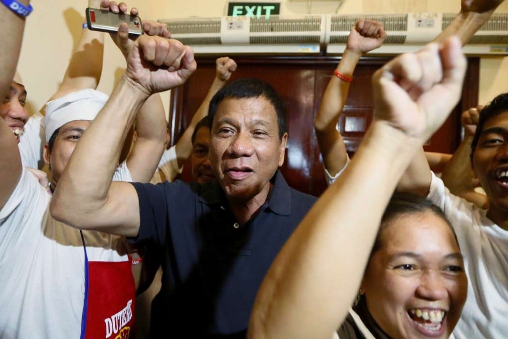 Philippine presidential candidate Rodrigo Duterte being cheered by the kitchen staff of a restaurant in Manila. Photo: AP