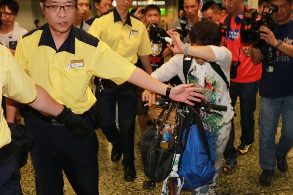 The owner of the battery as he is escorted by MTR staff at Sham Shui Po station in Kowloon. Photo: SCMP Pictures
