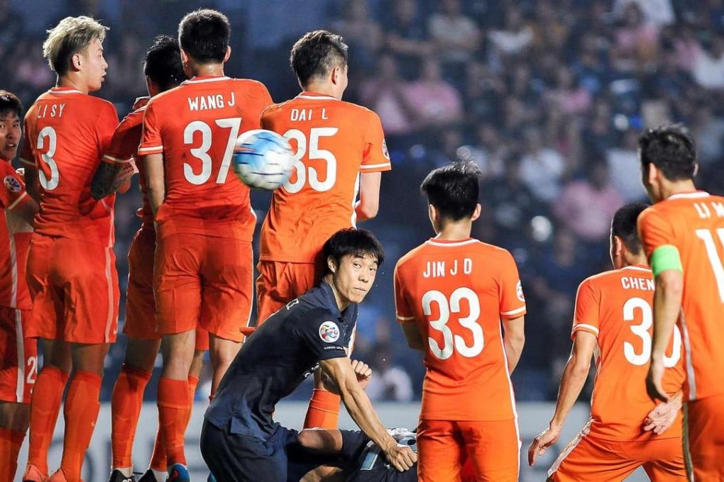 Shangdong Luneng players jump to counter a free kick by Buriram United in their AFC Champions League game in Thailand. Photo: AFP