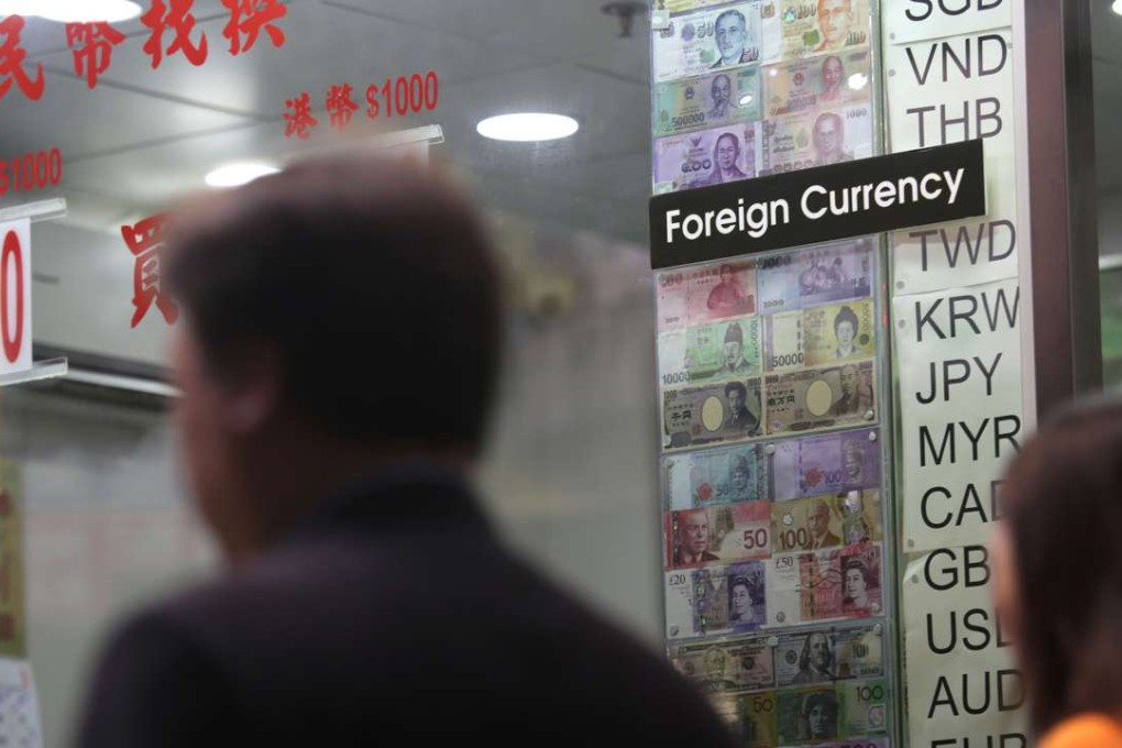 Pedestrians walk past a money exchange business in the Wan Chai district of Hong Kong on April 7, 2016. Photo: AFP