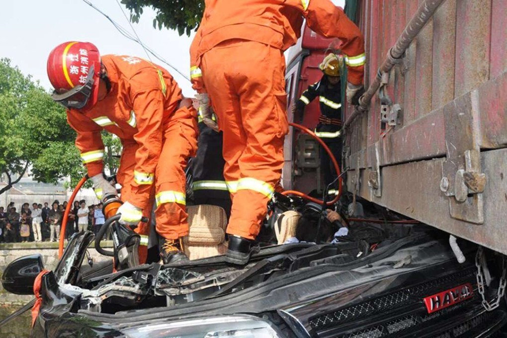 Firefighters cut open the wreckage of the car. Photo: Qianjiang Evening News