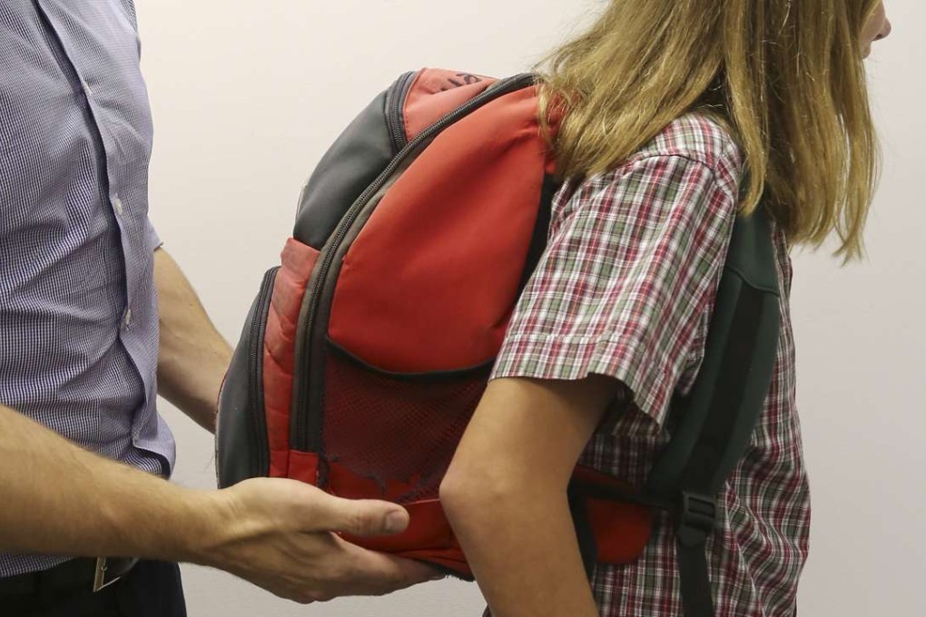 Physiotherapist Chris Sherer helps to adjust a backpack to place it in a suitable position. Photos: Jonathan Wong