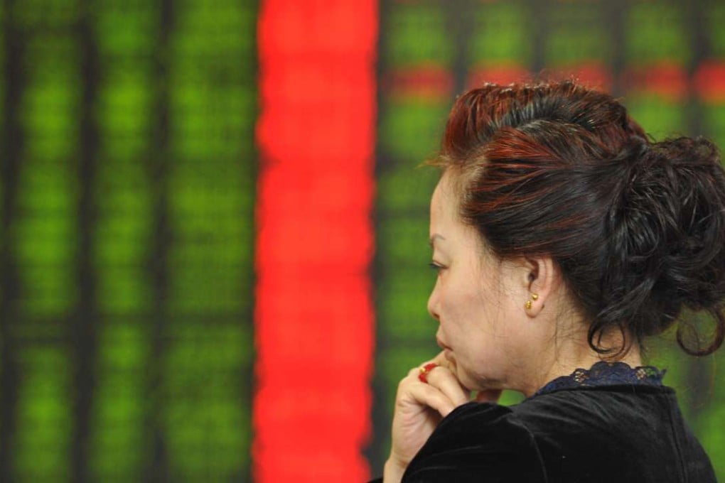 An investor stands in front of a screen showing stock market movements at a securities firm in Fuyang, Anhui province. Photo: AFP