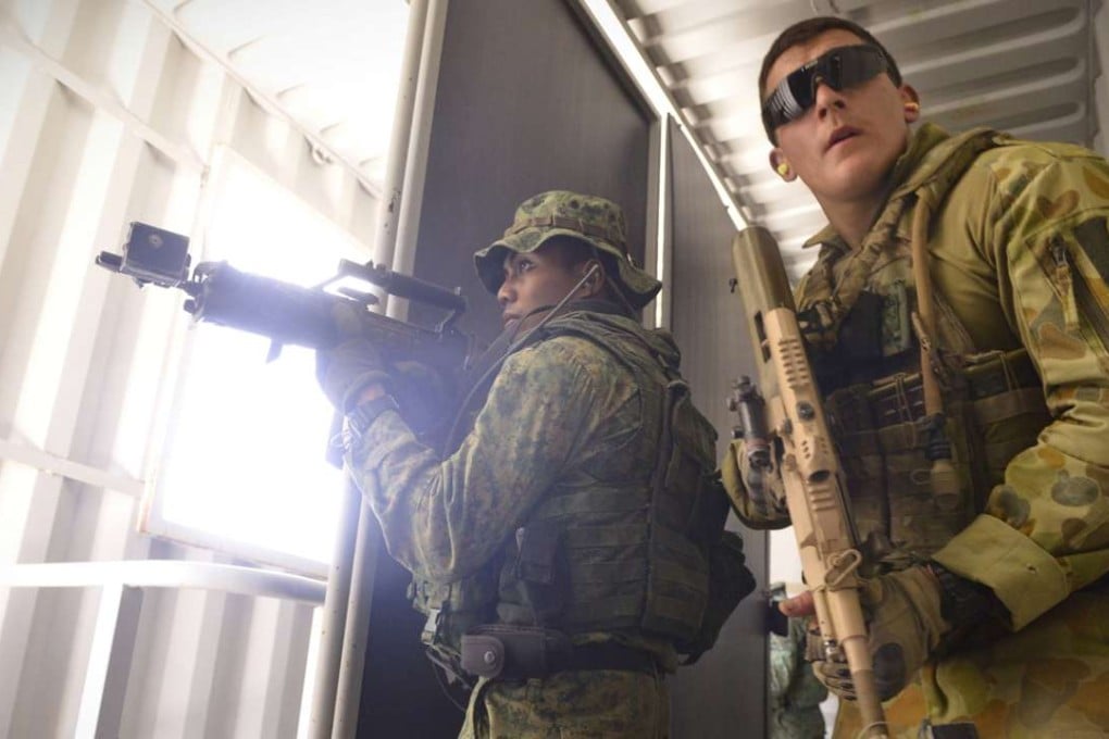 Soldiers from the Singapore Guards (left) and the 7th Australian Regiment clear a room during a dry run of an urban-based exercise at the Urban Operations Training Facility in Shoalwater Bay Training Area, Rockhampton, Australia on November 9, 2014. Photo: Reuters