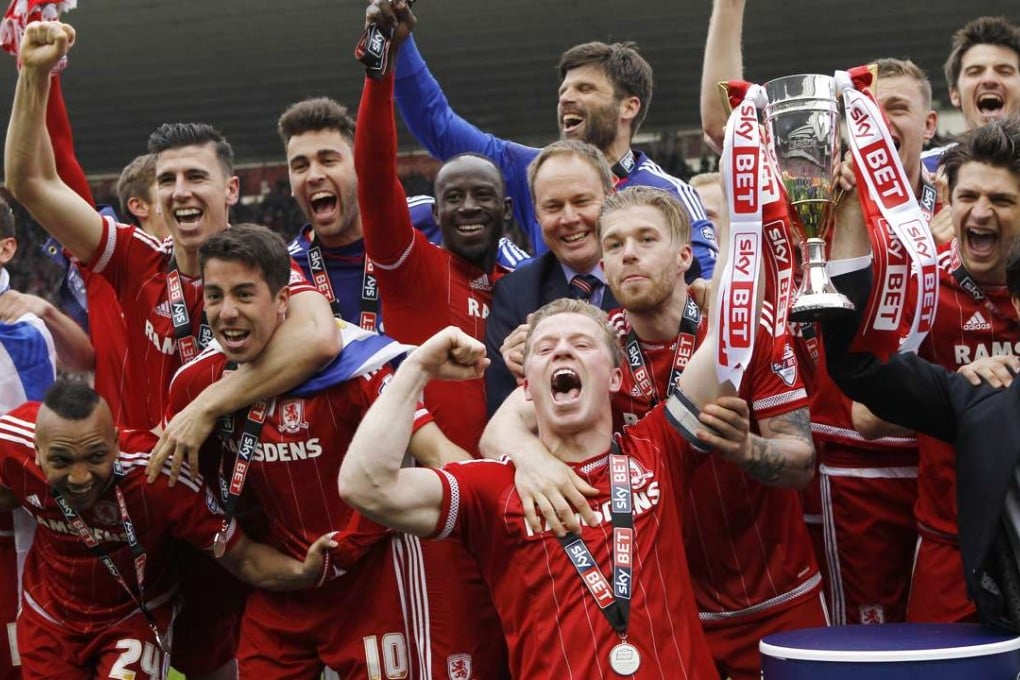 Middlesbrough's Grant Leadbitter celebrates with the trophy and teammates after being promoted to the Premier League. Photos: Reuters