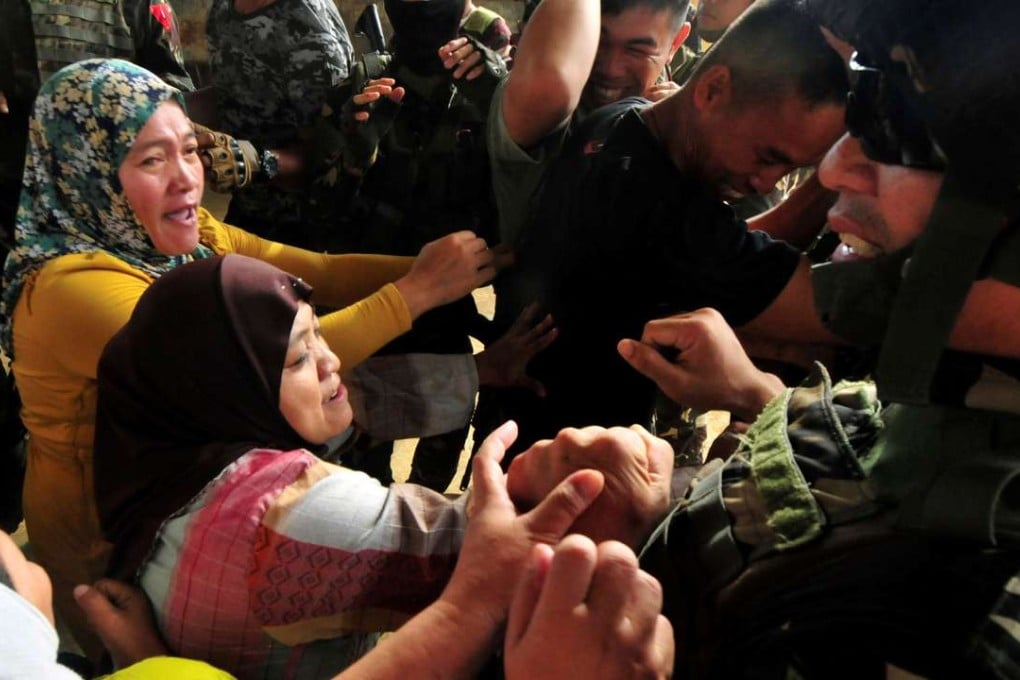 Government soldiers breakup a scuffle between a supporter of local candidate and a female soldier pinned underneath, during a military operation to deliver ballot counting machines in Madalum town, Lanao del Sur, southern Philippines on May 6, 2016. Photo: Reuters