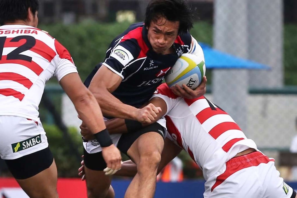 Hong Kong's Salom Yiu Kam-shing tries to crash through the Japanese defence at Hong Kong Football Club on Saturday. Photos: Jonathan Wong/SCMP