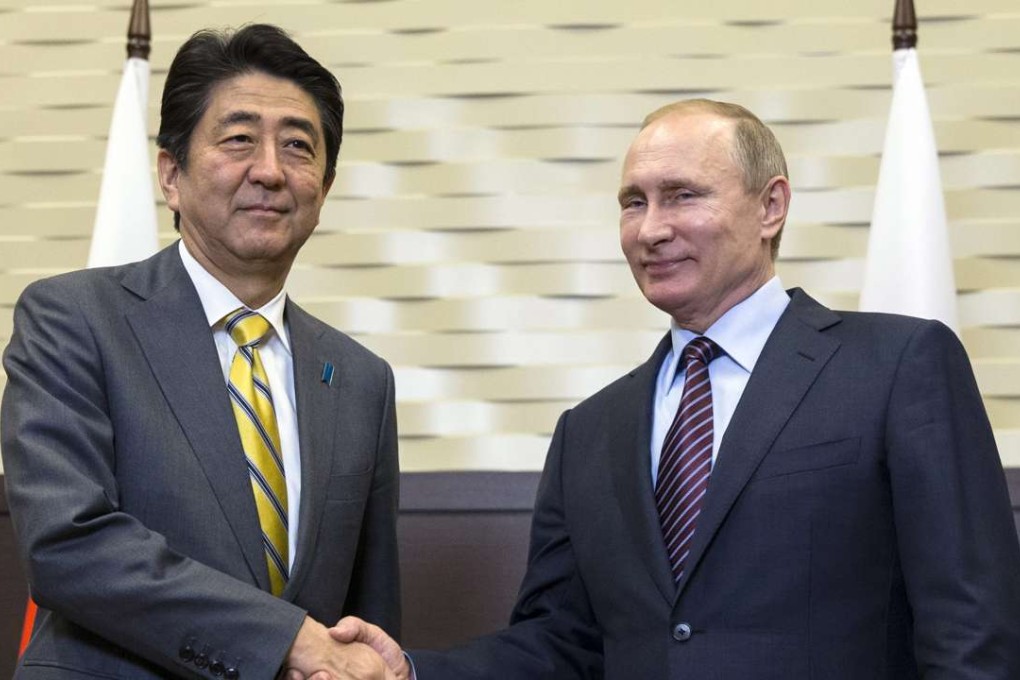 Russian President Vladimir Putin (right) shakes hands with Japanese Prime Minister Shinzo Abe. Photo: EPA