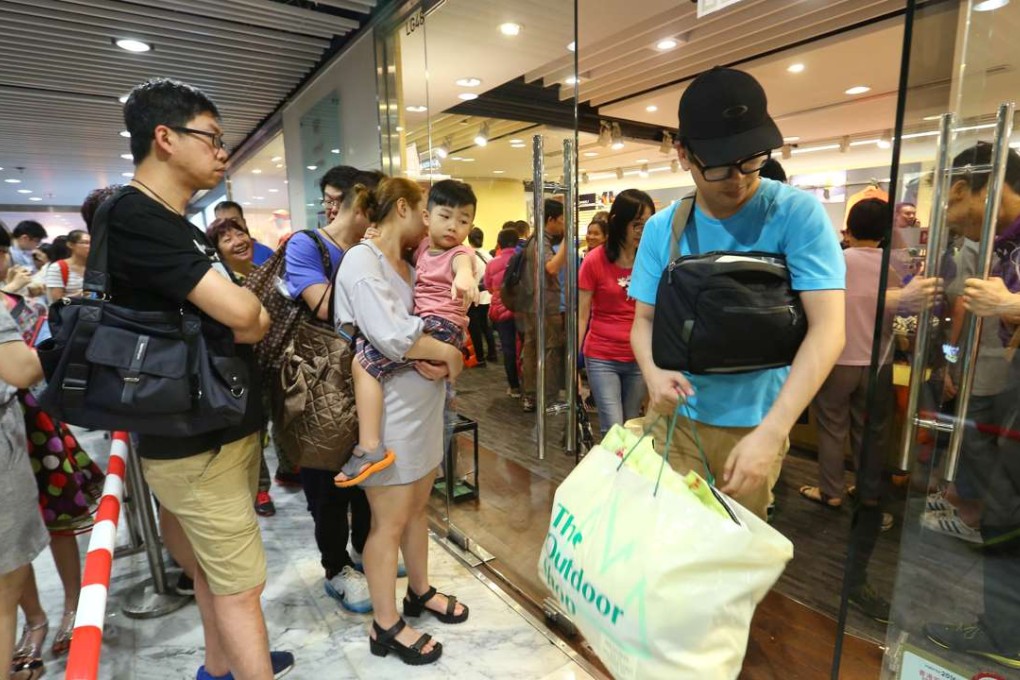 More than 200 people queue up outside the Outdoor Shop in TST on Saturday. The 27-year-old store is going to close down amid a poor “business environment”. Photo: Edmond So