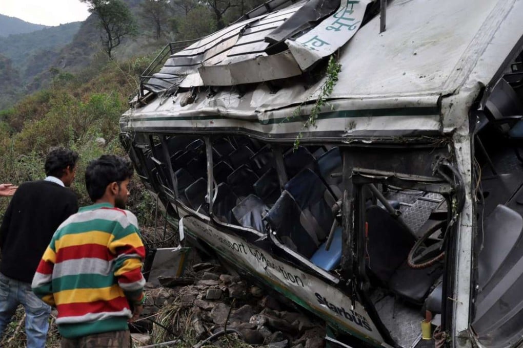 Indian people look at the mangled remains of the bus on the spot where it fell into a gorge, at Golu near Jogindernagar, Himachal Pradesh, India, 8 May 2016. Photo: EPA