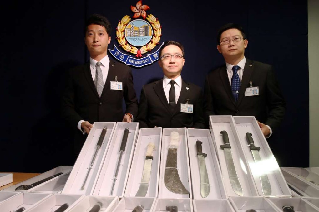 Hong Kong Police Organised Crime and Triad Bureau Senior Inspector Lee Ming-kong; Superintendent Yau Nai-keung; and Chief Inspector Wong Chun-yip show seized weapons at the police Headquarters in Wan Chai. Photo: Sam Tsang