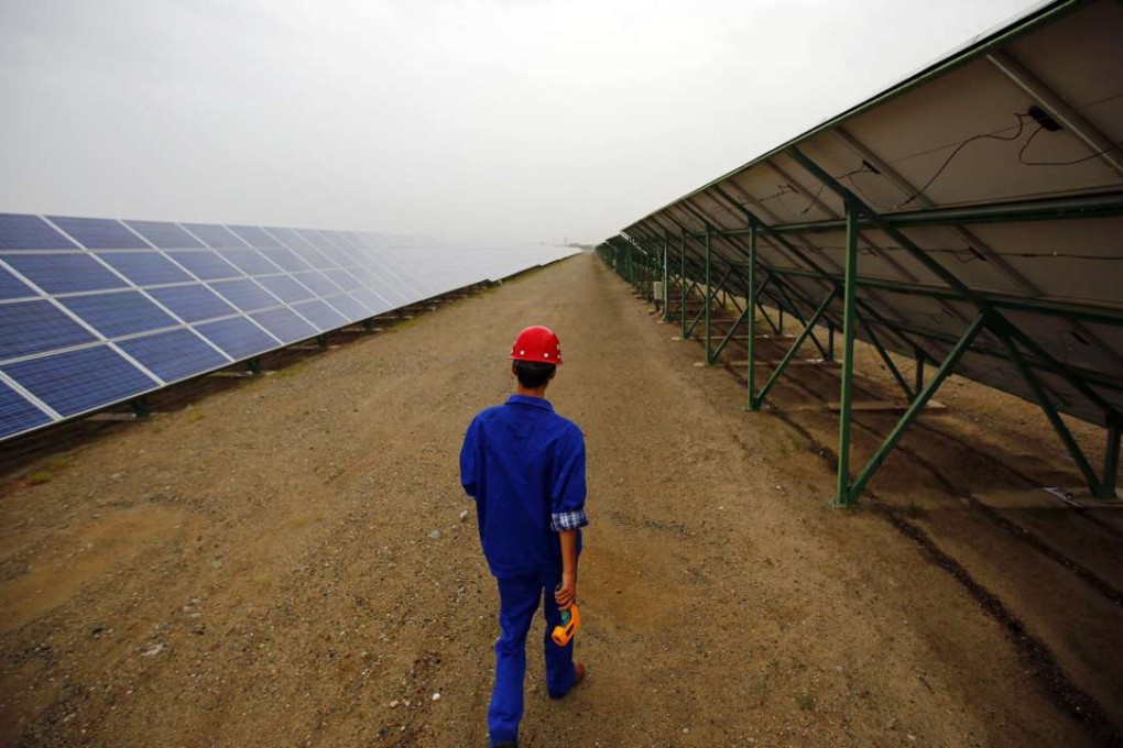 A worker inspects solar panels at a solar farm in Dunhuang, Gansu province. Photo: Reuters