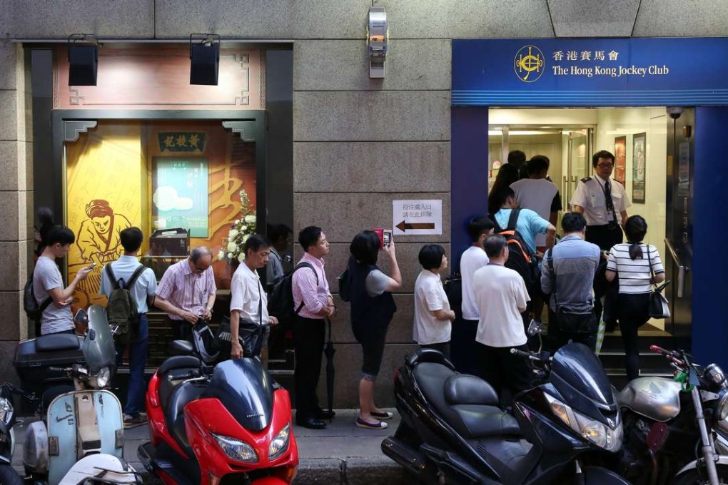 People queue for Mark Six tickets at a Hong Kong Jockey Club outlet in Central. Photo: Sam Tsang