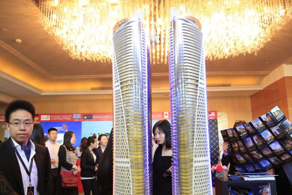 Visitors check out a property model on display during the Luxury Property Showcase Beijing 2016 event at a hotel in Beijing. Photo: EPA