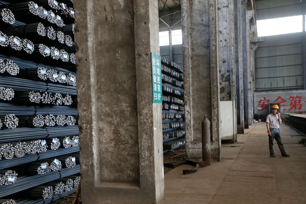An employee talks on his mobile phone near stacks of rebar at Shanxi Zhongsheng Iron and Steel in Fenyang, Shanxi province, China, April 28, 2016. Photo: Reuters