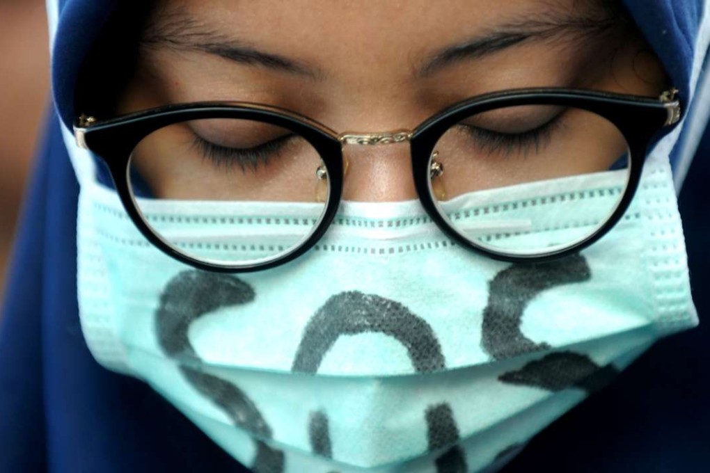 A girl wearing a mask with a sign of SOS attends solidarity for Yuyun in Jakarta, Indonesia on May 4, 2016. Yuyun, a 14-year-old girl, was killed in early April after being gang raped by 14 males in a small village of Sumatra. Indonesian President Joko Widodo on Wednesday called for severe punishment for the group of men charged with raping and killing Yuyun, a case that has angered rights groups who say the government is not doing enough to protect women and children. Photo: Xinhua