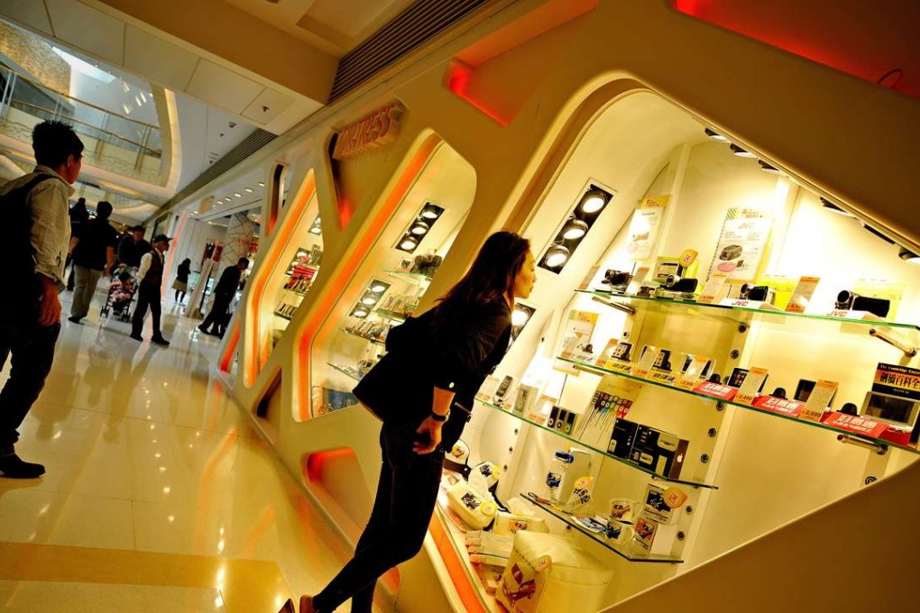 A woman looks at a shop window in a shopping mall in Hong Kong . PHOTO; AFP, Philippe Lopez