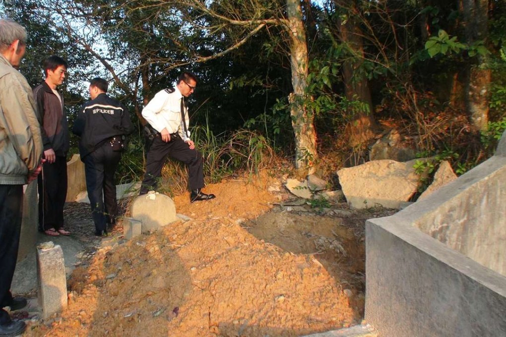 Police officers investigate a raided tomb at Hang Hau Village. Photo: SCMP Pictures