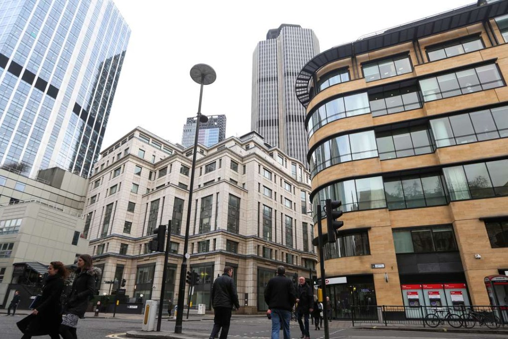 Pedestrians cross the road near the London headquarters of Deutsche Bank AG, right. Photo: Bloomberg