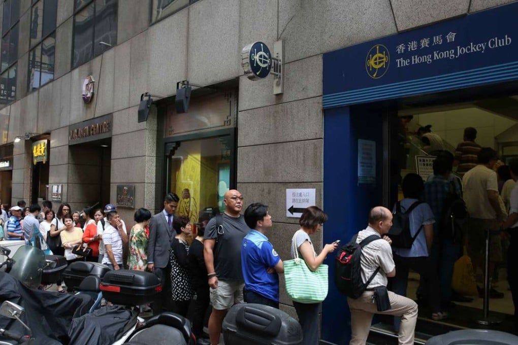 The heat did not stop a long line from forming outside this Jockey Club betting shop in Central. Photo: Sam Tsang