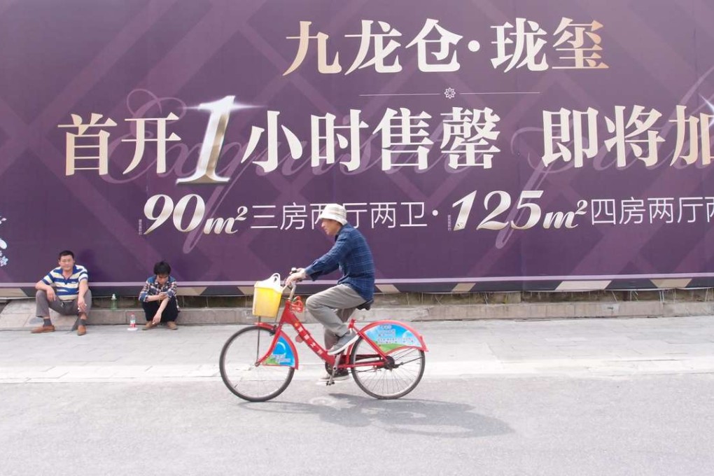 A cyclist goes past advertising for a development in Hangzhou’s Gongshu district. Led by The Wharf (Holdings), it sold out the first batch of nearly 90 units of flats in just one hour in April. .Photo: Summer Zhen