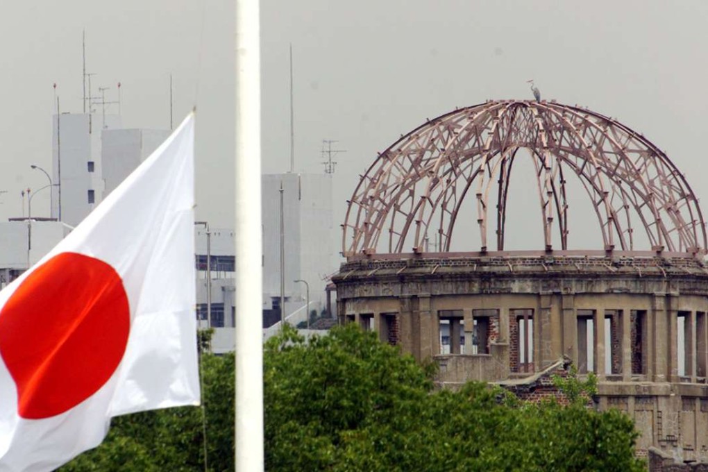 The Japanese national flag flutters at half-mast in the foreground of the atomic bomb dome at the Hiroshima Peace Memorial Park. Photo: Reuters