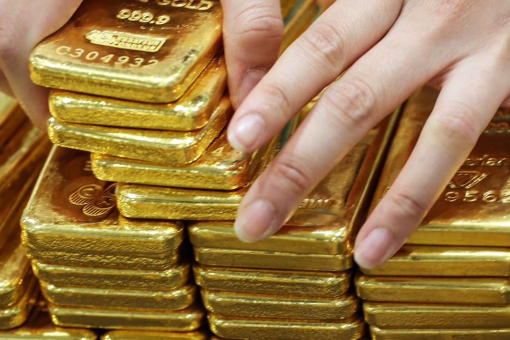 A bullion store employee arranges one kilogram gold bars in Bangkok. Photo: Bloomberg