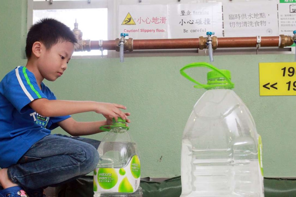Edmond Ng Yat-long, 8, fetches water from temporary pipes on a floor at Sheung Ching House in Kai Ching Estate during the water scare last year. Photo: May Tse