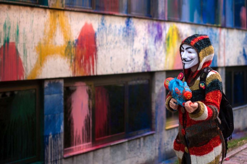 A protester wearing a Guy Fawkes mask, sprays paint with toy water gun on the facade of the Macedonia's Public Revenue Office headquarters oin Skopje, as part of series of protests that have been running almost for a month now Photo; AFP Robert Atanasovski