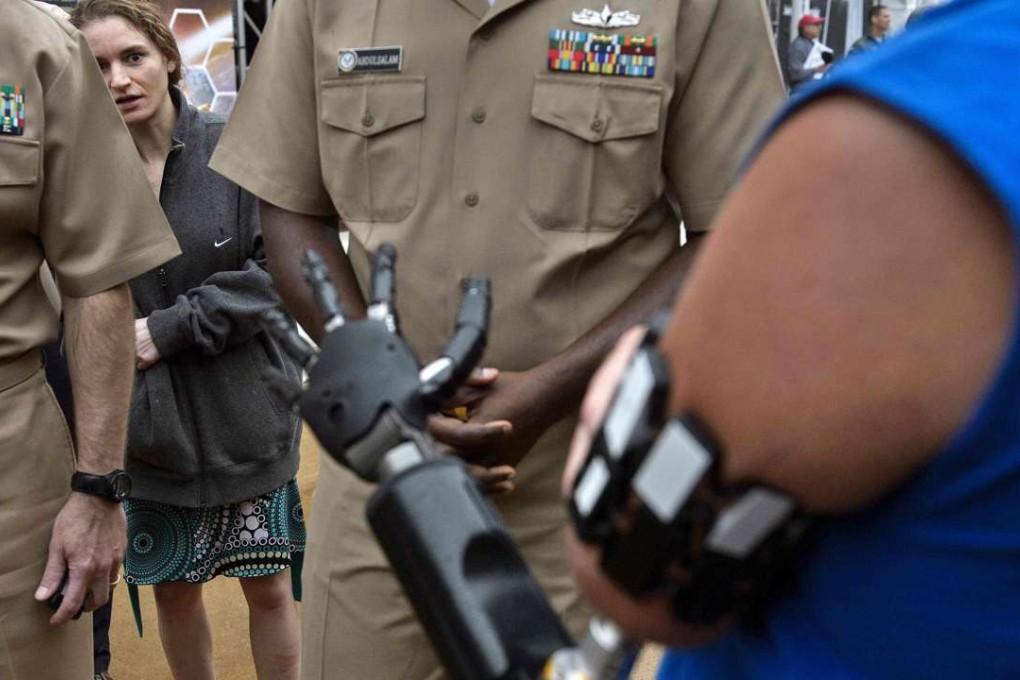 Johnny Matheny, who lost his arm to cancer, shows people his robotic limb during the Defence Advanced Research Projects Agency Demo Day at The Pentagon on Wednesday. Photo: AFP