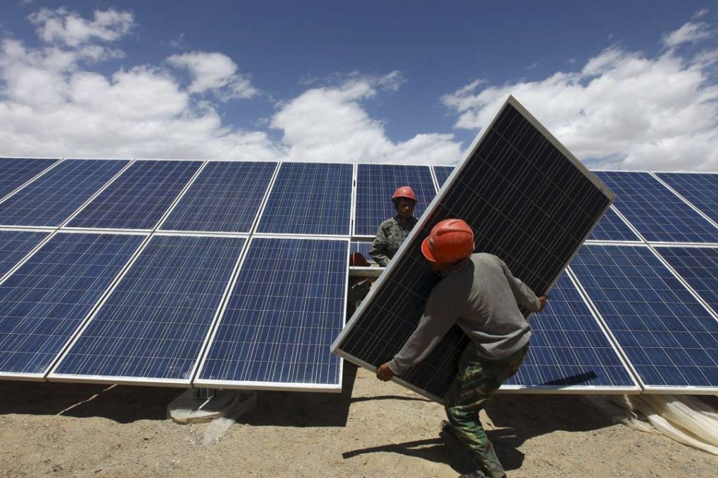 Workers install a solar panel at a solar farm in Gansu province. Photo: Reuters