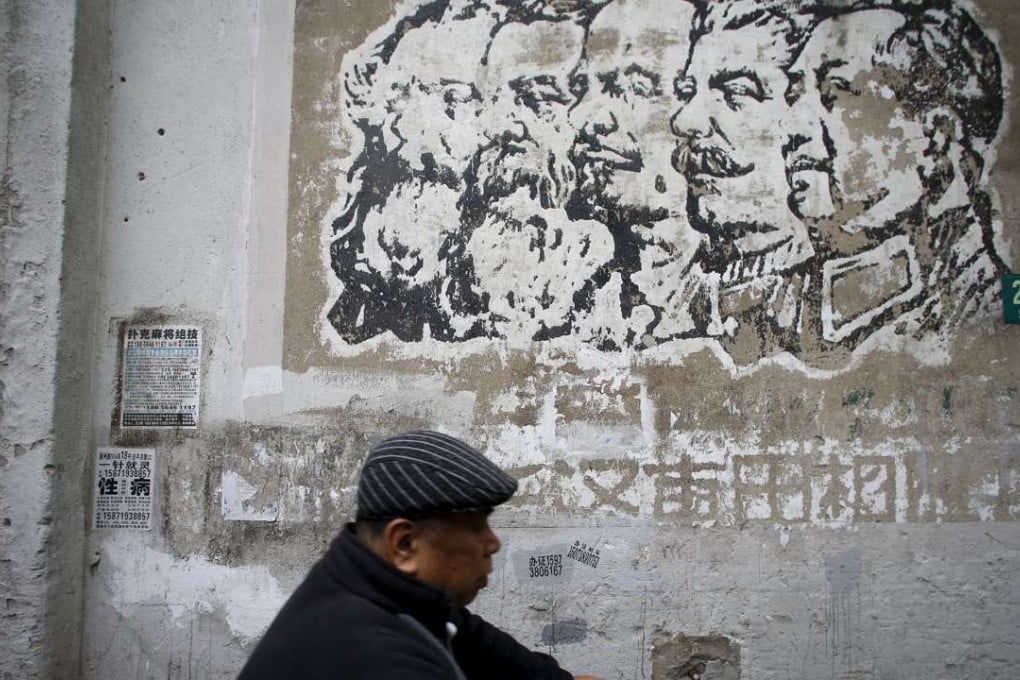 A resident rides an electric bicycle past an image painted during the Cultural Revolution, depicting German philosophers Karl Marx and Friedrich Engels, Soviet leaders Nikolai Lenin and Joseph Stalin, and Chinese leader Mao Zedong, on a wall at a soon-to-be-demolished housing area in Shanghai. Photo: Reuters