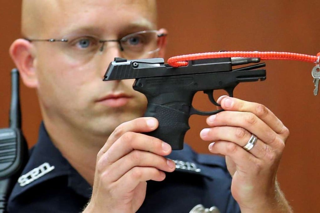 Sanford police officer Timothy Smith holds up the gun that was used to kill Trayvon Martin, while testifying during George Zimmerman's murder trial in Seminole circuit court in Sanford, Florida, in 2013. Photo: Reuters