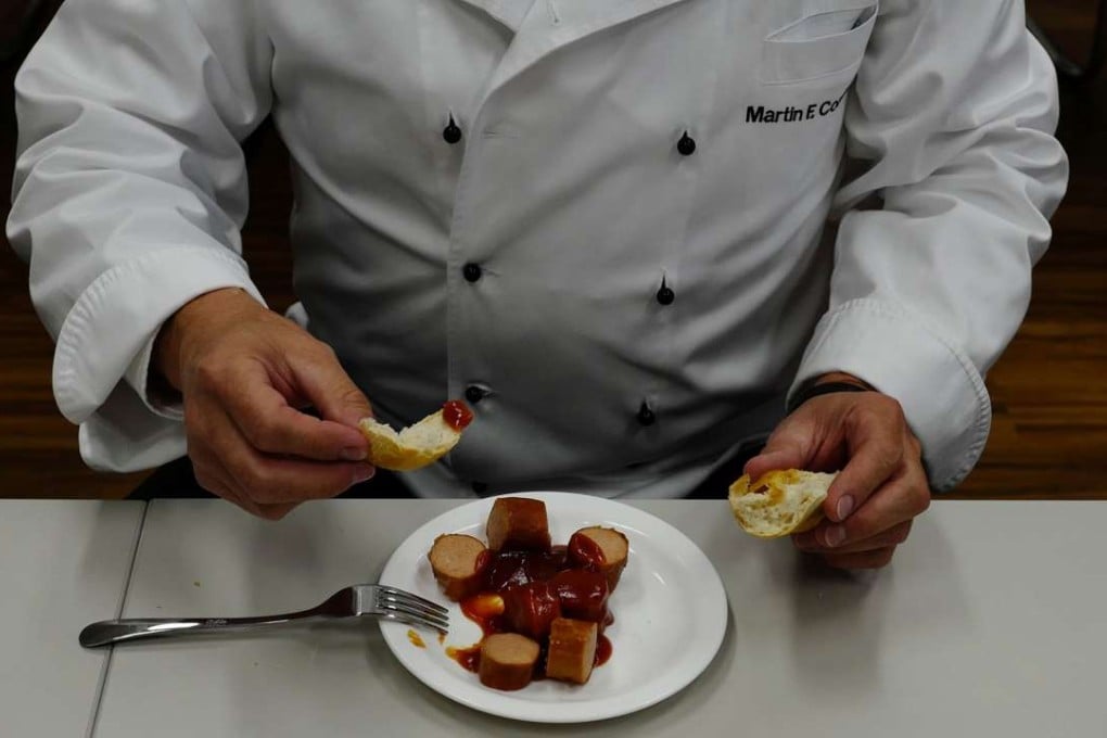 Martin Cordes, the director of Volkswagen’s food services, eating a plateful of the firm’s currywurst at its headquarters in Wolfsburg, central Germany. Photo: AFP