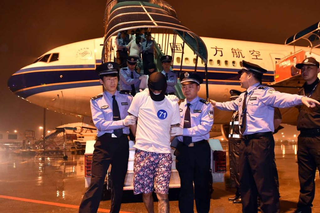 Telecom fraud suspects are escorted off an aircraft by the police at Guangzhou Baiyun International Airport in Guangzhou in April. Photo: Xinhua