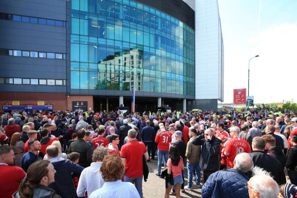 Spectators stand outside Old Trafford after being evacuated following the discovery of a suspect device in the stadium. Photo: AP