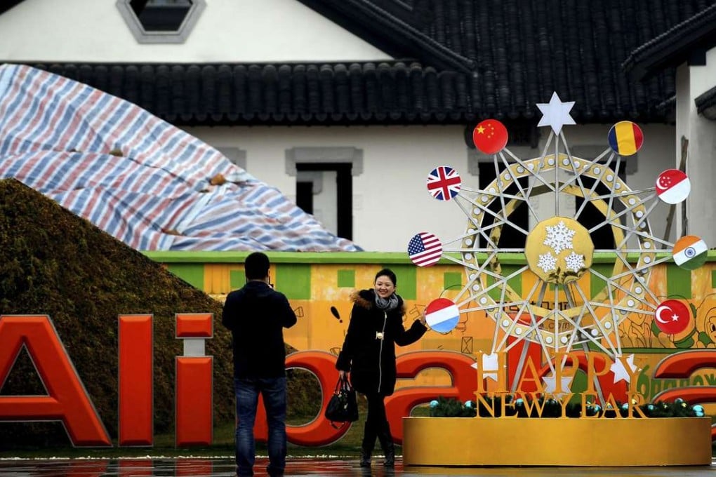 A visitor poses outside the Alibaba headquarters in Hangzhou, eastern Zhejiang Zhejiang province. Photo: AP