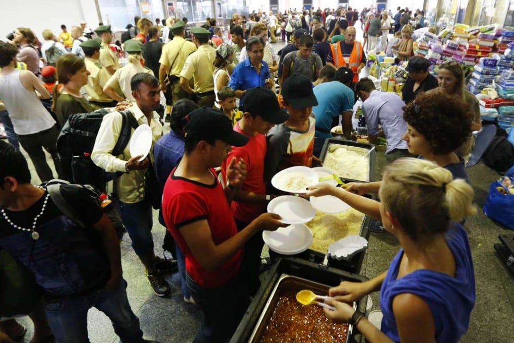 Volunteers distribute food for migrants coming from Budapest at the main station in Munich, Germany. Photo: AP