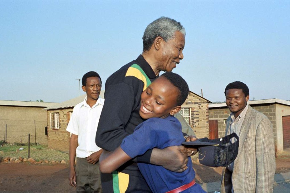 Nelson Mandela hugs a young Sowetan girl as he visits the black township of Soweto near Johannesburg , on October 4, 1990. Photo: AFP