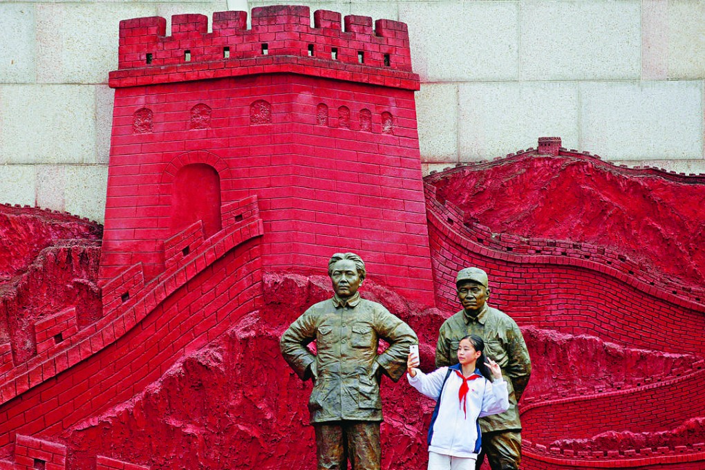 A girl takes a selfie stood between statues of late Chinese chairman Mao Zedong, left, and former general Zhu De at Jianchuan Museum in Anren, Sichuan province, China. Photo: Reuters