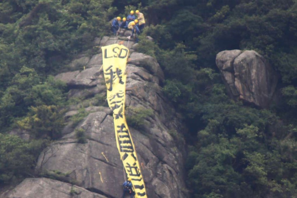 Firemen approaching the yellow banner with the words reading: "I want genuine universal suffrage" in Chinese which been put up at Beacon Hill this morning. 17MAY16 SCMP/ Sam Tsang