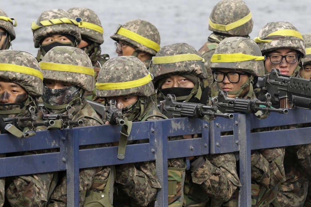 South Korean army soldiers aim their machine guns on a truck as they cross a floating bridge on the Nam Han River during an annual military exercise in Yeoju, South Korea. File photo: AP