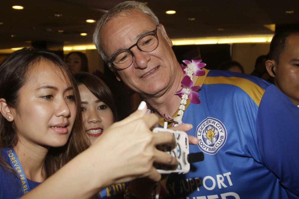 Who would not want a selfie with Leicester City manager Claudio Ranieri? A Thai soccer fan gets a priceless memento as the team arrived in Bangkok on Wednesday. Photo: AP