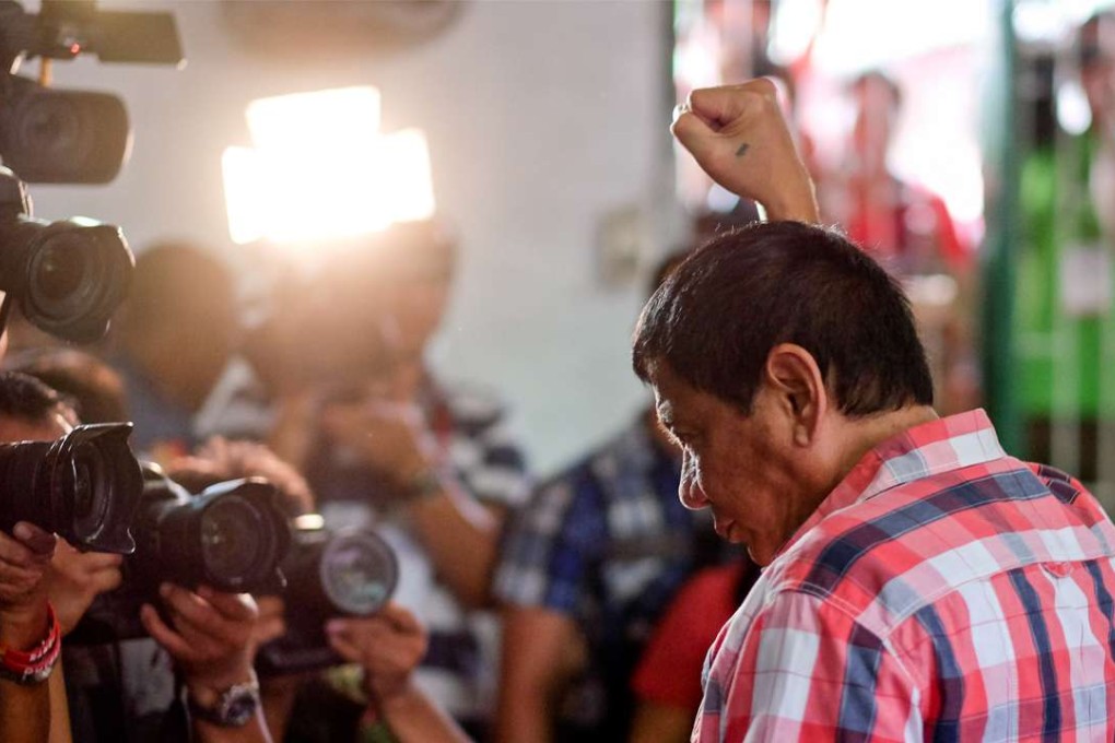 Rodrigo Duterte, Mayor of Davao and presidential candidate, gestures to members of the media at a polling station during the presidential election in Davao, Mindanao, the Philippines on Monday, May 9, 2016. Photo: Bloomberg