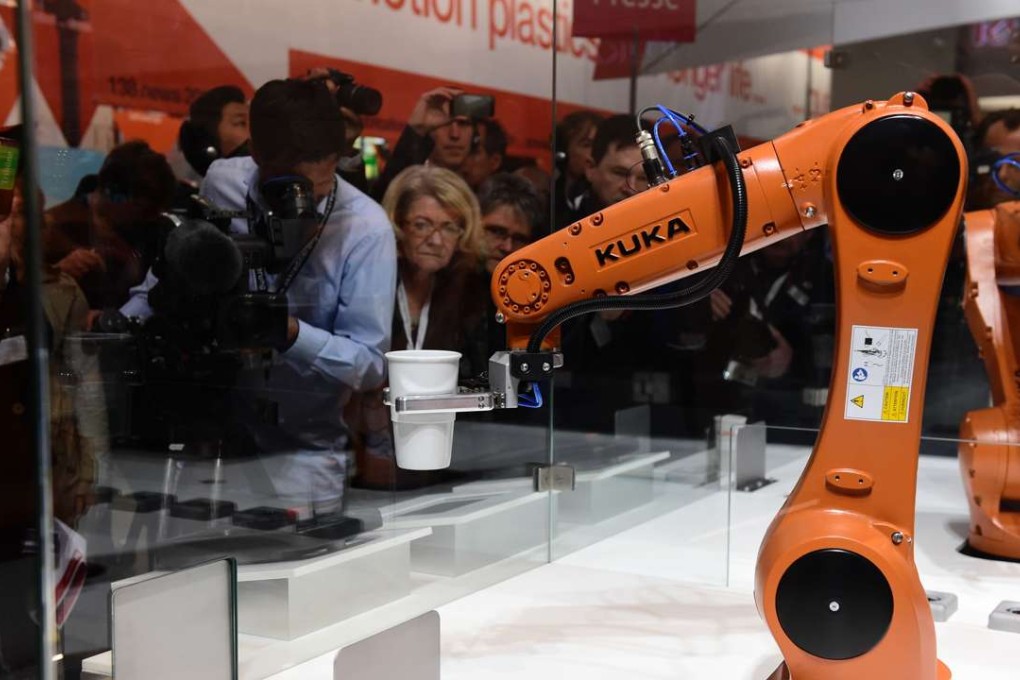 A robot prepares a cup of coffee at the booth of robotics manufacturer KUKA on the eve of the opening of the Hannover Fair in northern Germany. Photo; AFP, Tobias Scwarz