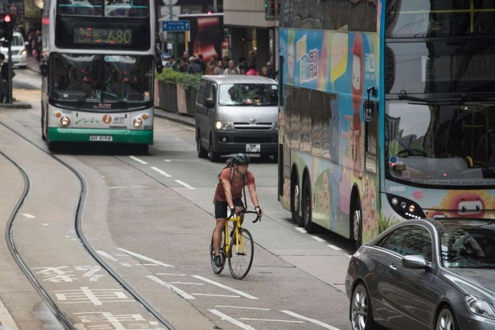 A bike commuter in Hong Kong navigates through heavy traffic. Photo: Alamy