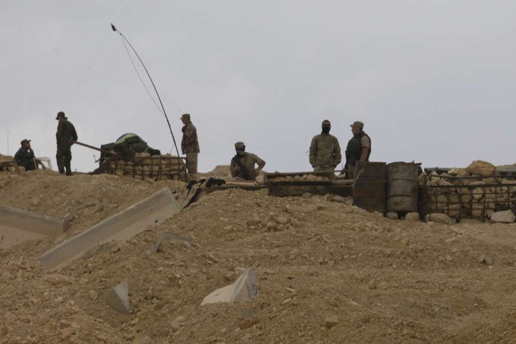 Russian soldiers stand guard at a check point at the entrance that leads to the Palmyra citadel in the central Homs province, Syria. Photo: AP