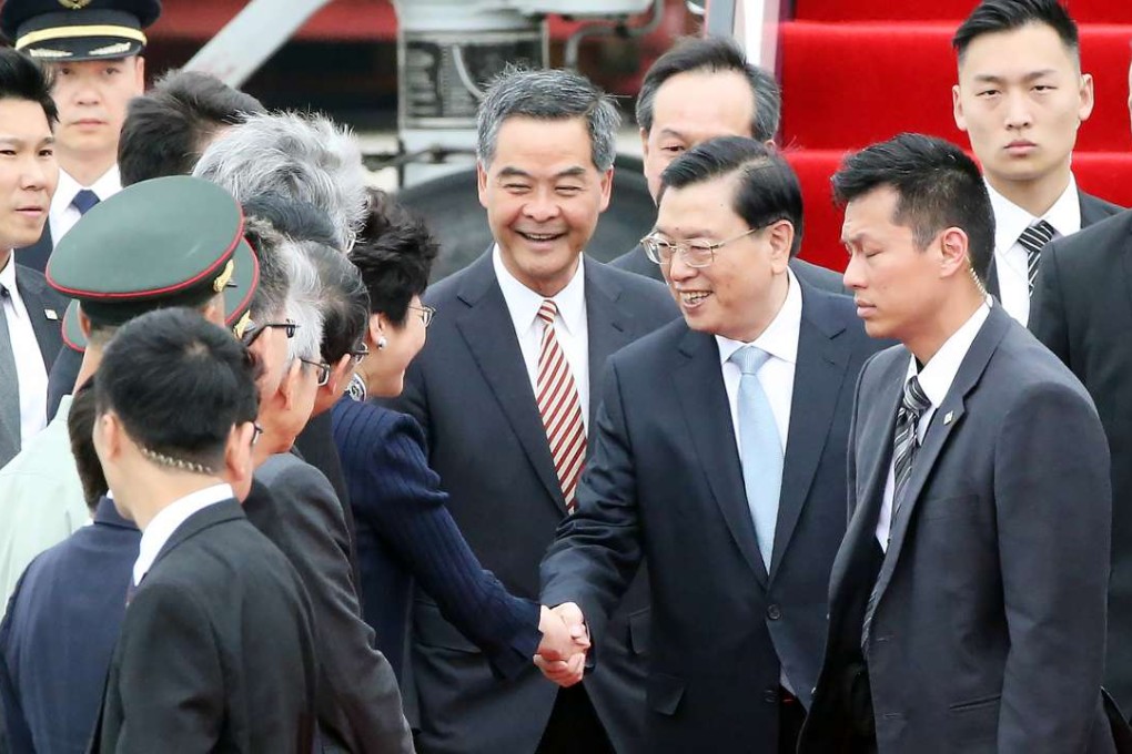 Zhang Dejiang shakes hands with Chief Secretary Carrie Lam Cheng Yuet-ngor after arriving at the airport, as Leung Chun-ying (centre) looks on. Photo: Felix Wong