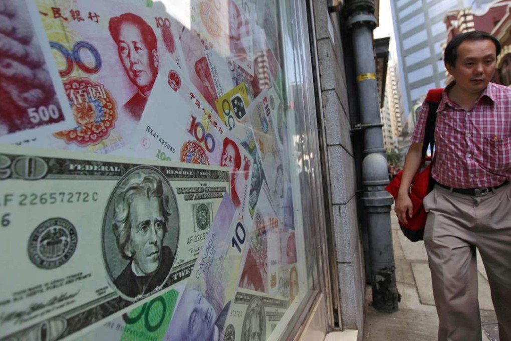 A man walks past a display of oversized banknotes outside a foreign exchange office in Hong Kong. Photo: EPA